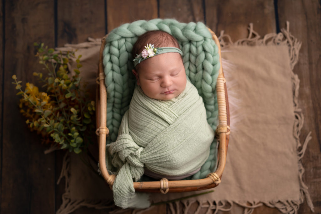 Photo bébé emmailloté tons pastels et bandeaux dans petit contenant. Cindy Fernandez Photographe naissance bébé aix marseille